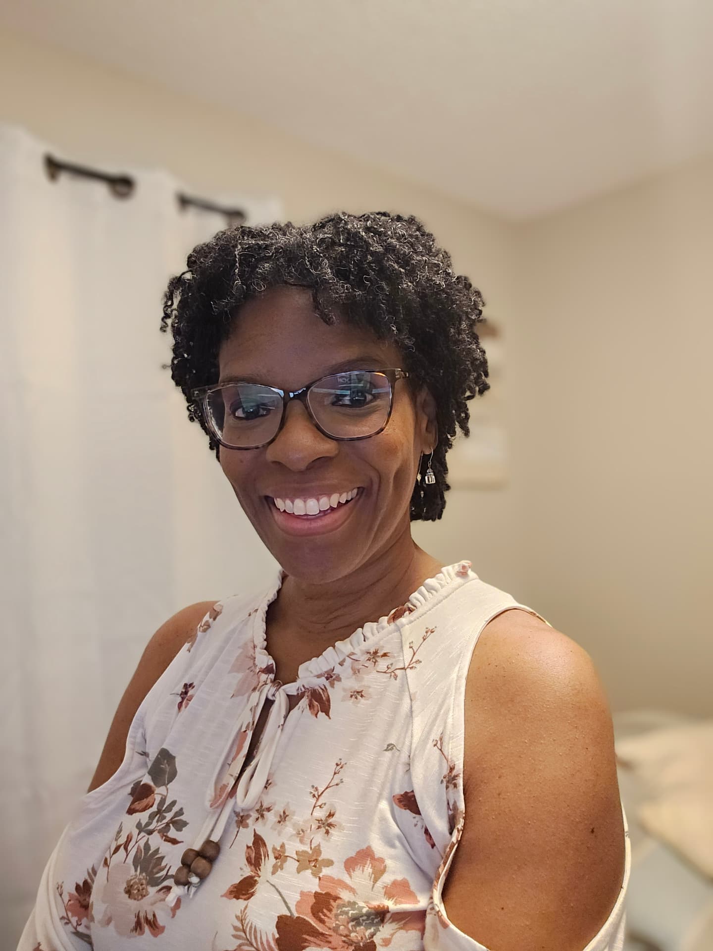 Chef Roxie, founder of Vendor Village, smiling in a floral top and glasses